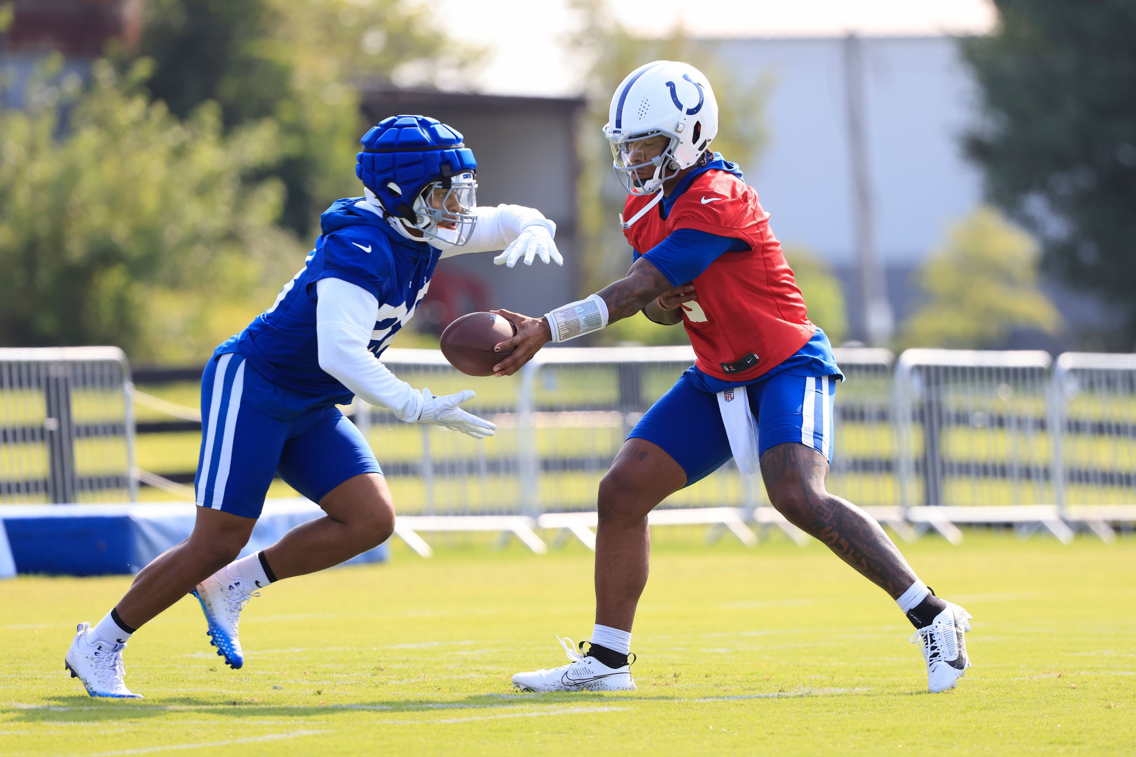 Anthony Richardson #5 of the Indianapolis Colts hands the ball off to Jonathan Taylor #28 during training camp at Grand Park Sports Campus