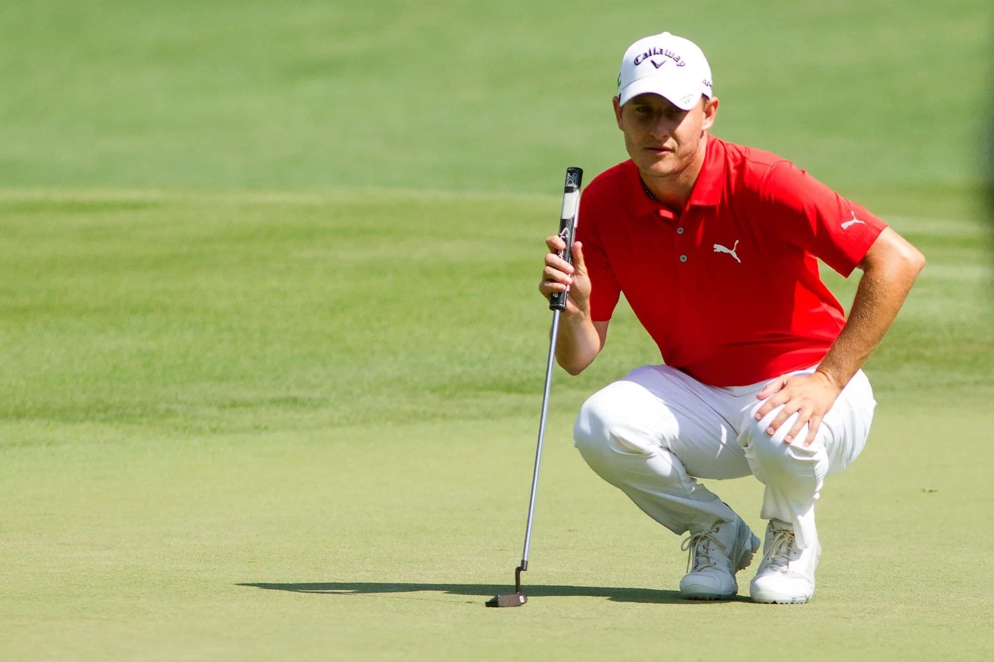 Joshua S. Kelly lining up a putt