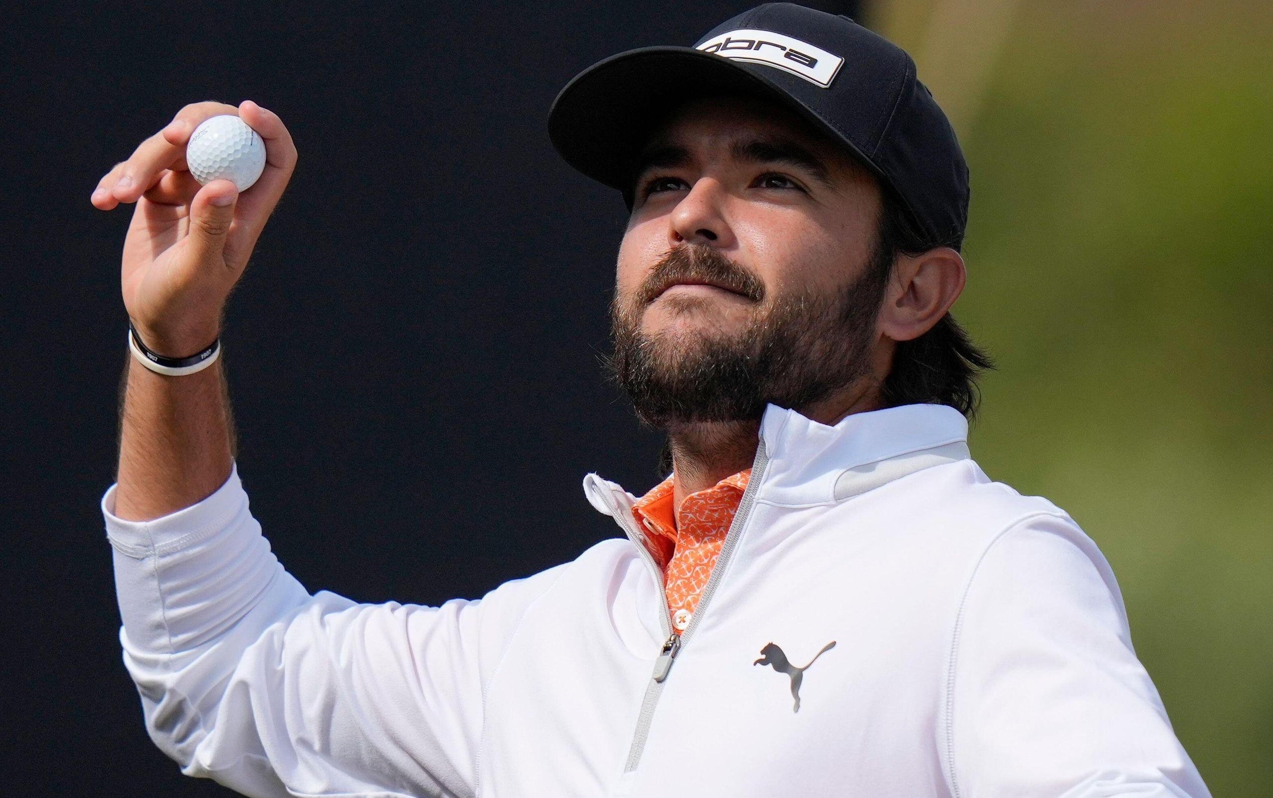 Angel Hidalgo throws a ball to the crowd on the 18th green
