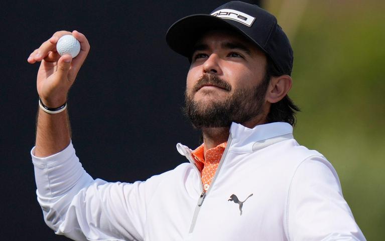Angel Hidalgo throws a ball to the crowd on the 18th green